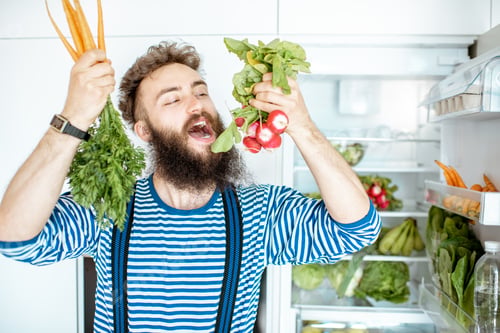 Preview: Man with vegetable food near the fridge at home
