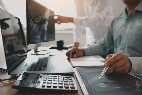Preview: Two investors are working together with analyzing the stock data graphs in the paper and viewing the