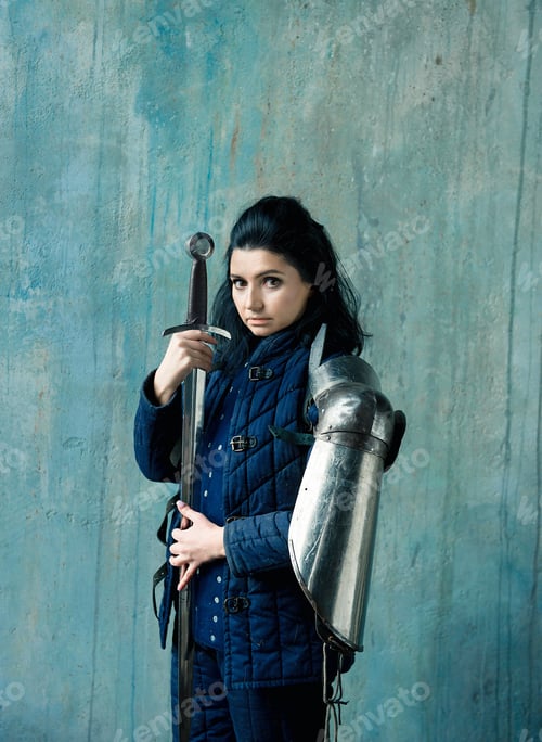 Preview: Beautiful brunette woman in ancient iron knightly armor. Medieval female knight in armor.