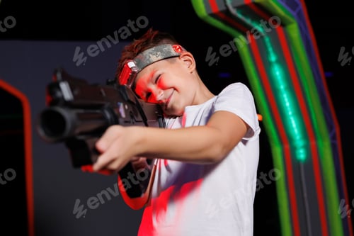 Preview: Joyful boy plays laser tag game. Child having fun in game entertainment center.