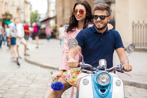 Preview: young beautiful hipster couple riding on motorbike city street