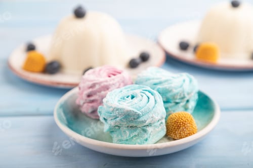 Preview: White milk jelly with marshmallow on blue wooden, side view, selective focus.