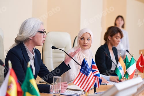 Preview: Mature confident female speaker in elegant suit explaining her opinion
