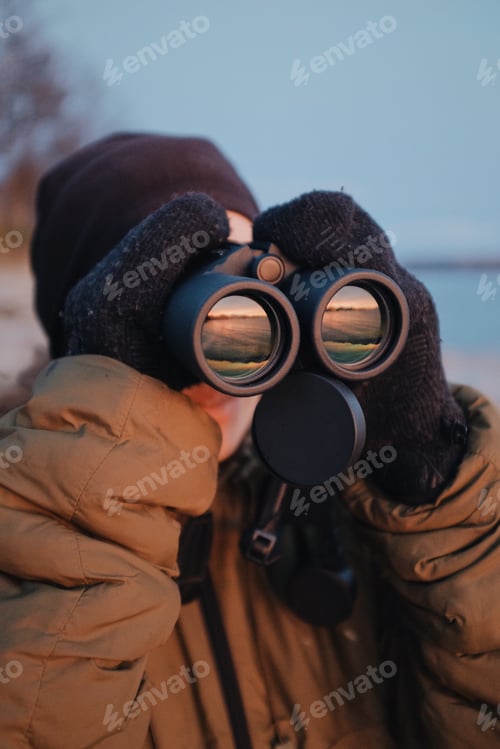 Preview: Caucasian woman using a binoculars outdoors,norway birdwatching