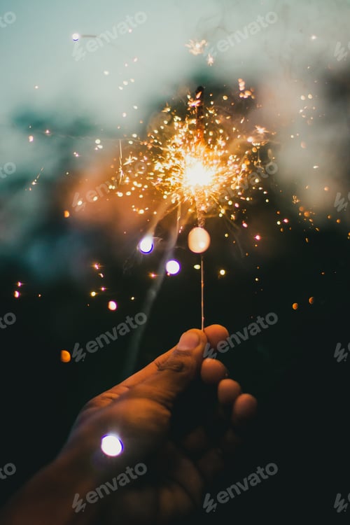 Preview: Hand holding a sparkler in the blurred background