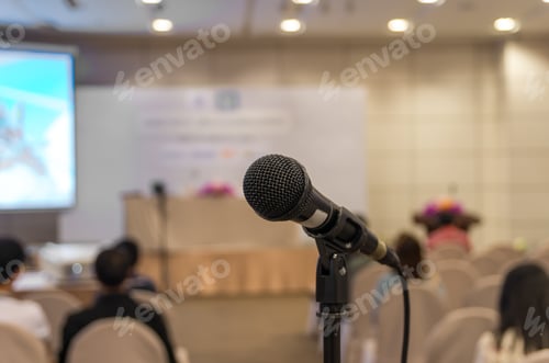 Preview: Microphone over the Abstract blurred photo of conference hall or seminar room background