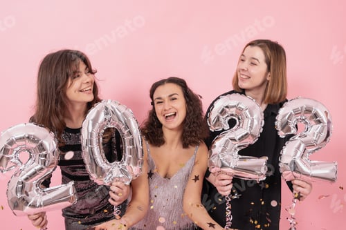 Preview: A group of cheerful girls with silver balloons in the form of the numbers 2022.