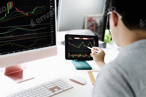 Preview: Investment professionals point their pen at their computer monitor to analyze the stock market for