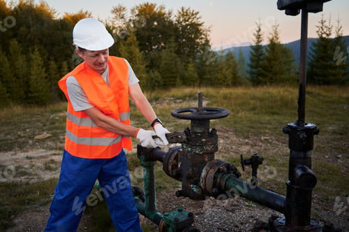 Preview: Mechanic in overalls working with wrench on pipeline.