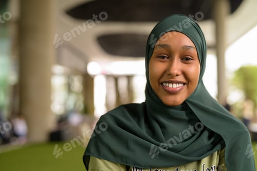 Preview: Portrait of beautiful black African Muslim woman smiling outdoors