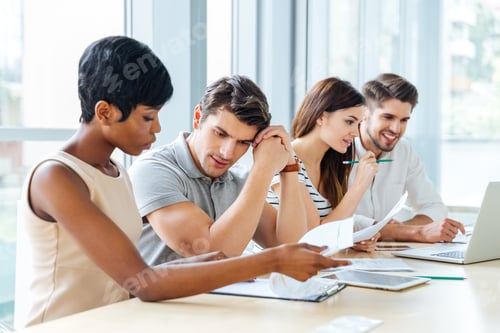 Preview: Business people sitting and working with documents in office