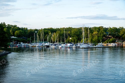 Preview: Travel to Sweden, Stockholm Archipelago. Moored boat at port in Baltic sea. Lush nature cloudy sky.