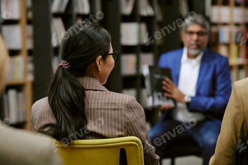 Preview: South Asian Middle Aged Man Sharing Book Insights with Diverse Adult Group