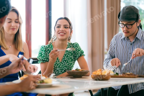 Preview: Happy people laughing enjoying meal having fun sitting together at restaurant table, diverse friends