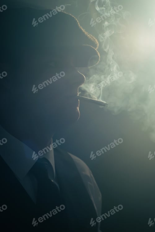 Preview: Retro Man With Cap Smokes Cigarette In Smoky Room. Side View.