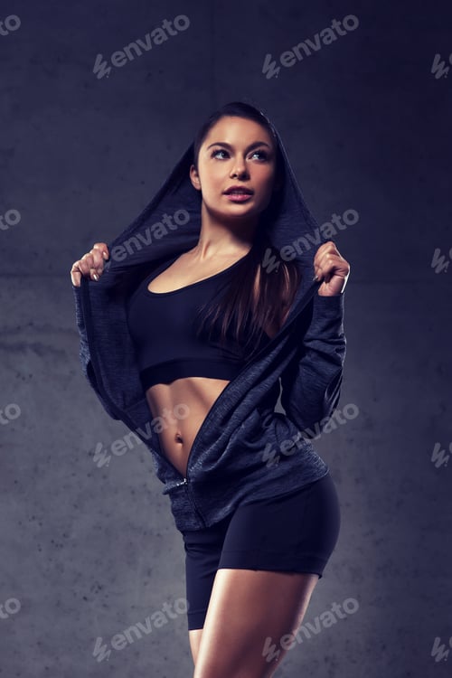 young woman posing and showing muscles in gym