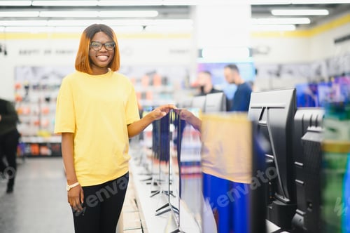 Preview: woman chooses plasma in store of household appliances, electronics and gadgets