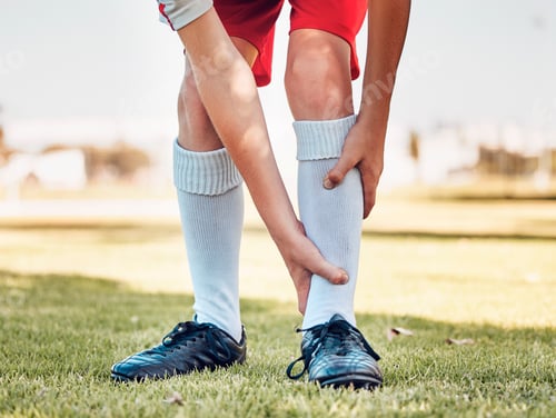 Preview: Shin pain, injury and accident of a soccer player playing a match or training on an outdoor field.