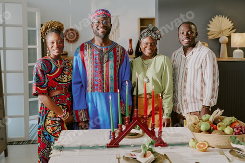Preview: Group of Black Adults Celebrating Kwanzaa Standing Around Kinara Candle Holder