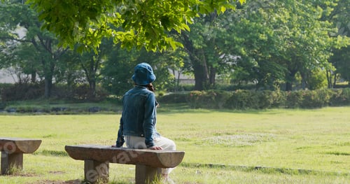 Preview: Woman sits on the wooden bench