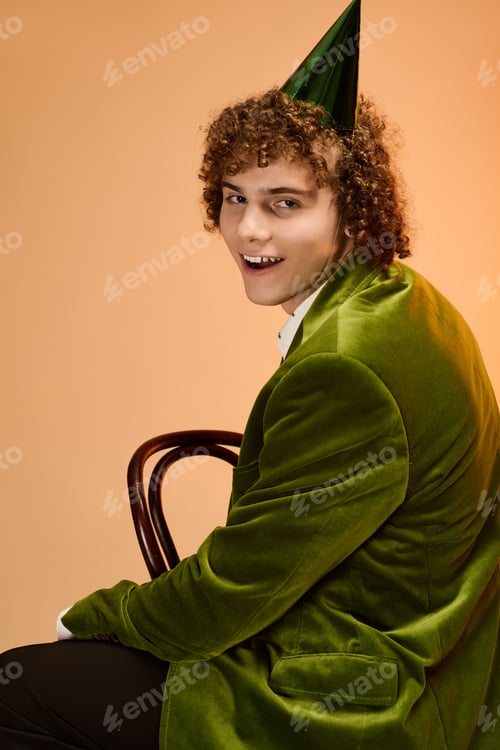 Preview: Curly teenage boy wearing a green velvet blazer in a vibrant studio setting