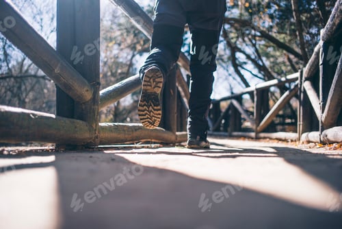 Preview: Mountaineer man walking on a bridge.