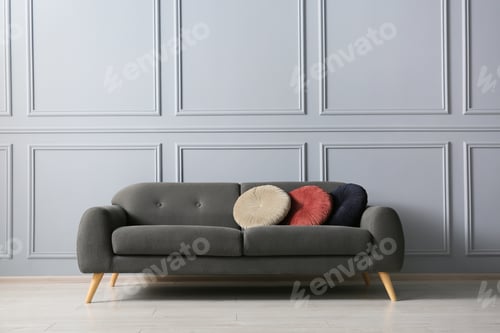 Preview: Stylish sofa with cushions near grey wall