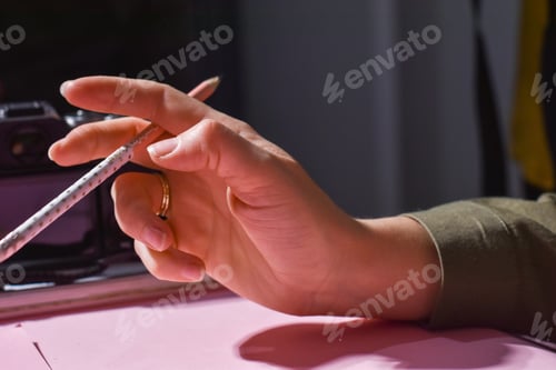 Preview: Woman's hand holding wooden pen, ready for drawing or to write.