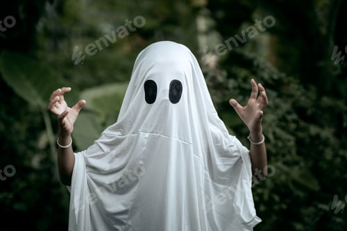 Preview: A young boy dressed as a ghost for Halloween wears a white sheet with two black eye holes