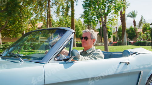 Preview: Side View Of Senior Couple On Road Trip Driving In Classic Convertible Car