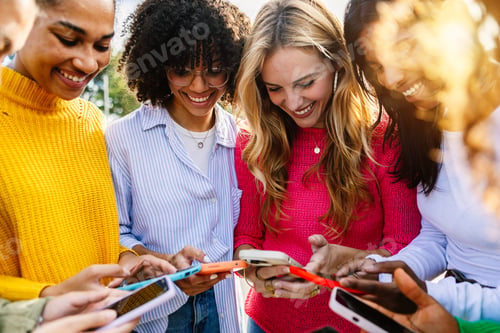 Preview: Young group of multiracial women using mobile phones together outdoor
