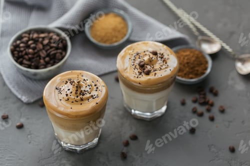 Preview: Glass of Iced Dalgona Coffee, trendy fluffy creamy whipped coffee and milk on grey background.