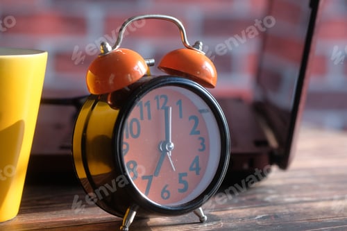 Preview: stack of books , laptop and clock on table close up