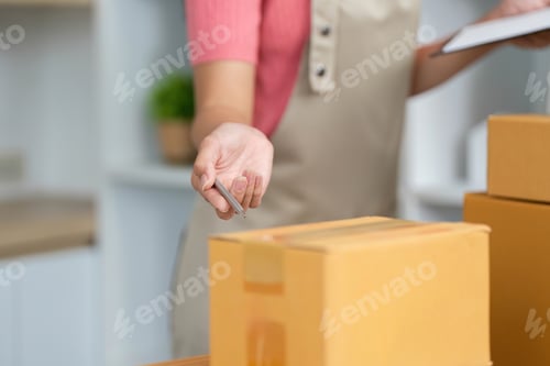Preview: Small Business Efficiency. A woman organizing packages with a pen in hand.