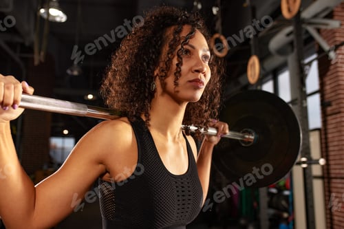 Preview: Sporty african american woman pumping up muscles with barbell, crossfit, weightlifting or deadlift