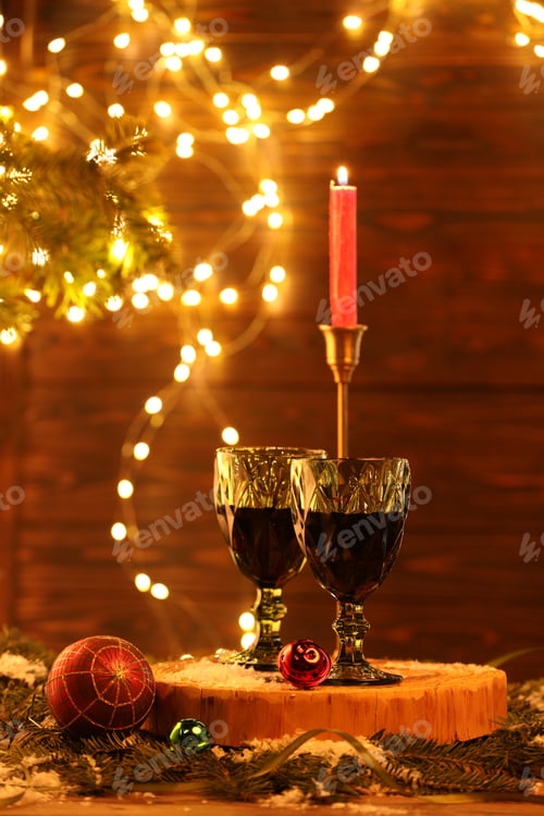 Preview: Red wine and beautiful Christmas decor on wooden table against blurred festive lights