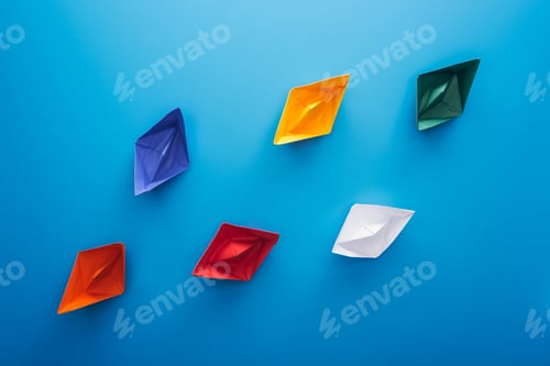 Preview: Flat lay with colorful paper boats on blue surface