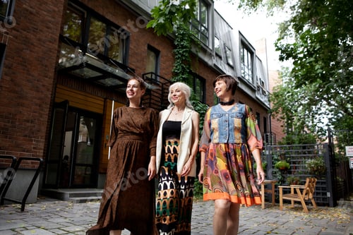Preview: Group of elderly fashionable women having fun walking city, three retired female friends