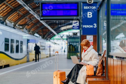 Preview: Confident middle aged caucasian redhead woman planning work on laptop during train stop
