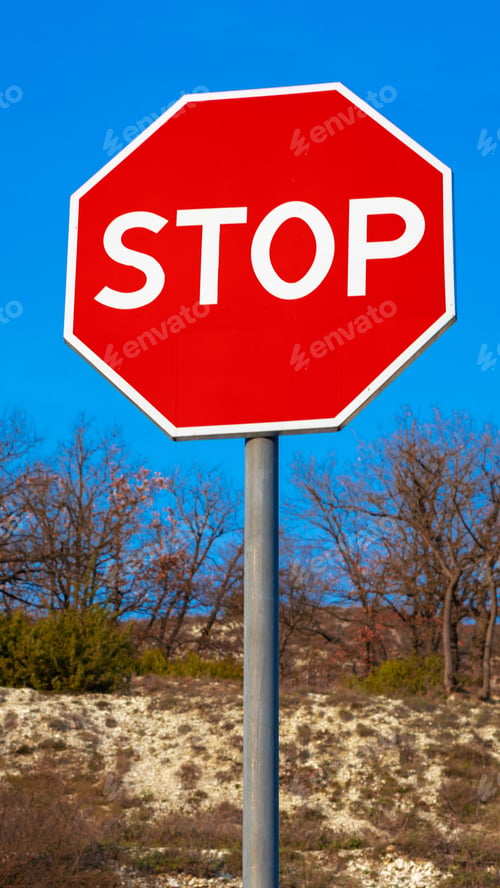 Preview: Clear stop sign stands tall against blue sky at roadside during daytime