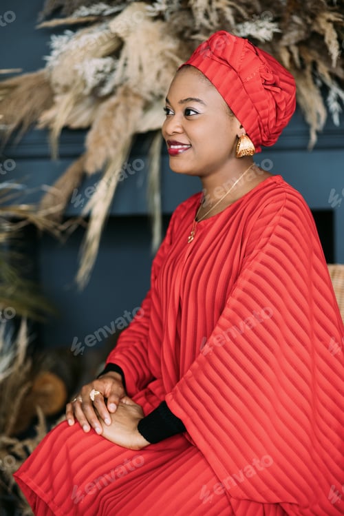 Preview: Waist up portrait of beautiful African-American female model in red ethnic dress and headwrap