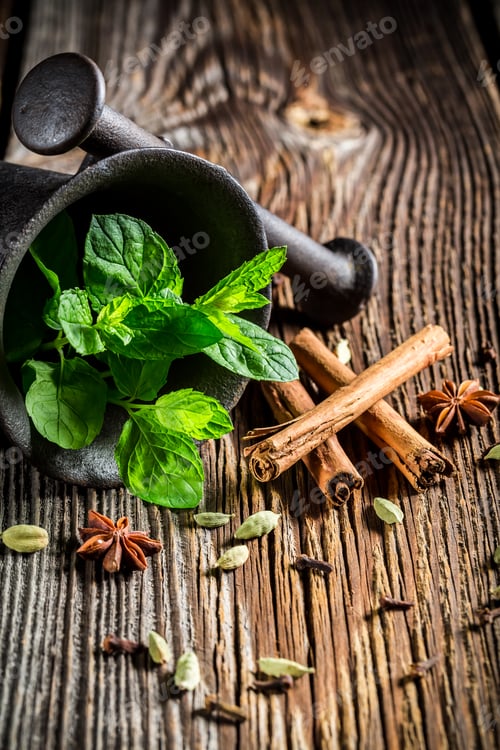 Preview: Spicy spices in mortar on old wooden table