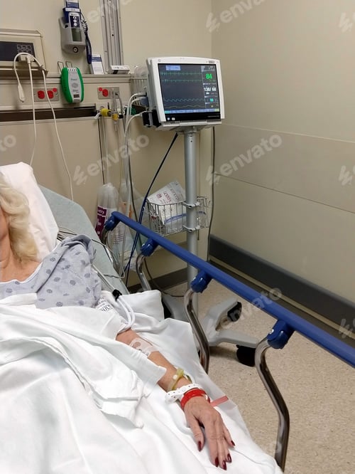 Preview: A female patient laying in a hospital bed gurney in ER Emergency Room hooked up heart monitor & IV