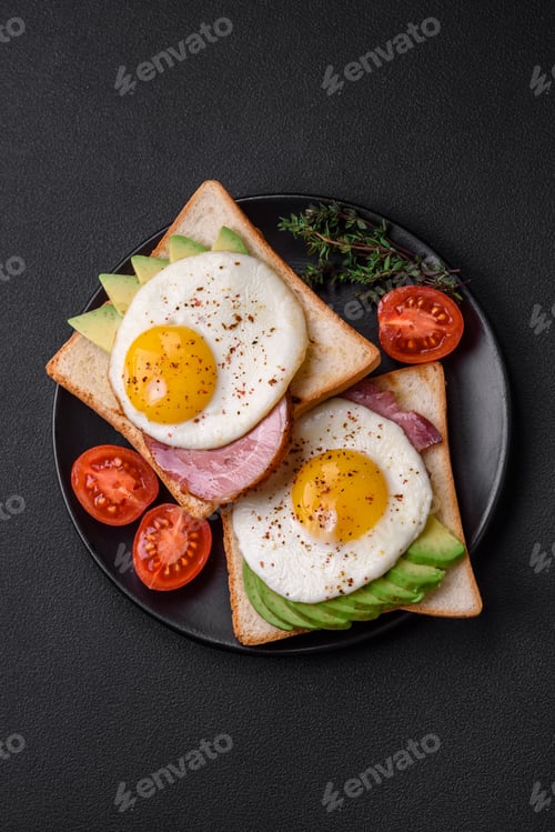 Preview: Delicious nutritious English breakfast with fried eggs, tomatoes and avocado