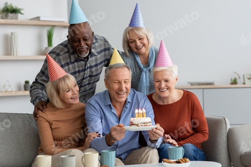 Preview: Multiracial group of senior people having birthday party at home