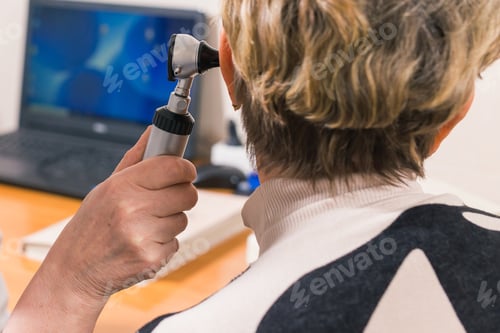Preview: Doctor using otoscope instrument to check womans ear in hospital, Healthcare workers in the
