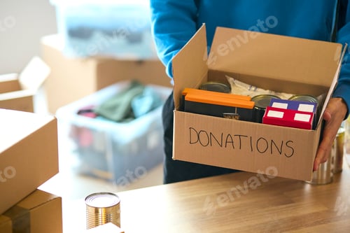 Preview: Close Up Of Male Charity Volunteer Working At Food Bank Unpacking Donations