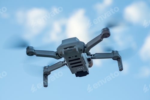 Preview: Consumer drone with camera hovering against sky