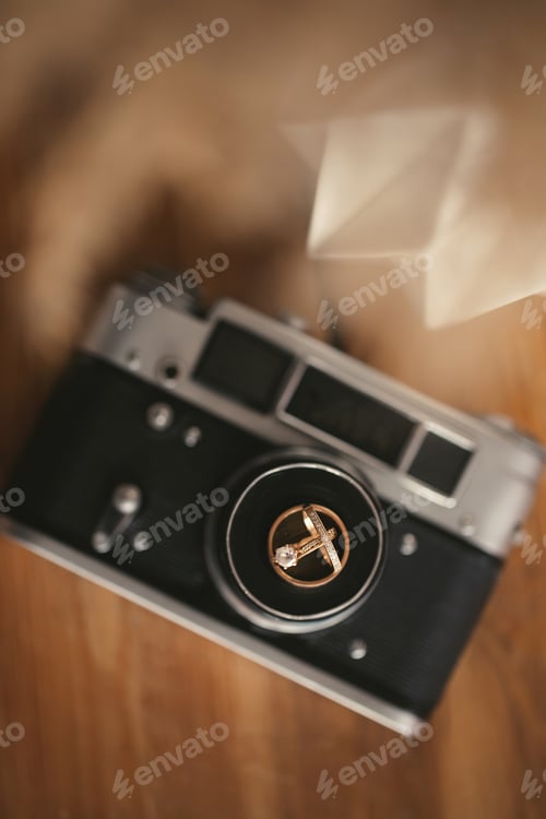 Preview: Wedding rings on an old camera. Details of the wedding day
