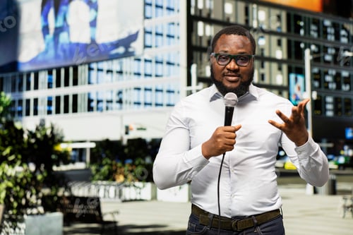 Preview: Black journalist talking on air with a microphone in hand doing field work